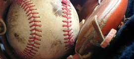 close up of baseball and worn glove